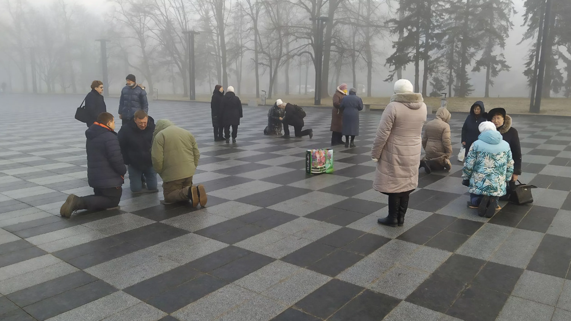 Ucranianos orando na praça central de Kharkiv, Ucrânia.