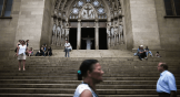 Pessoas passam em frente a uma igreja católica, no Brasil.