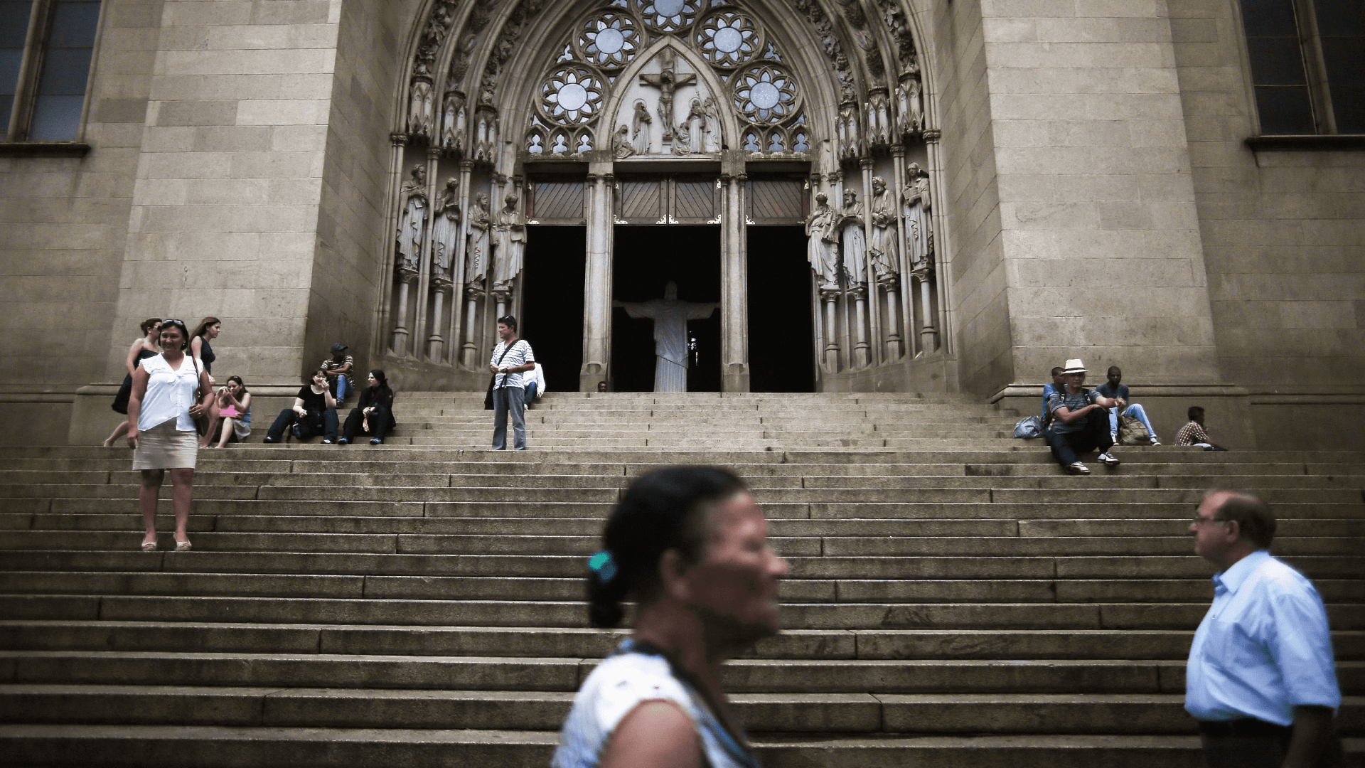 Pessoas passam em frente a uma igreja católica, no Brasil.