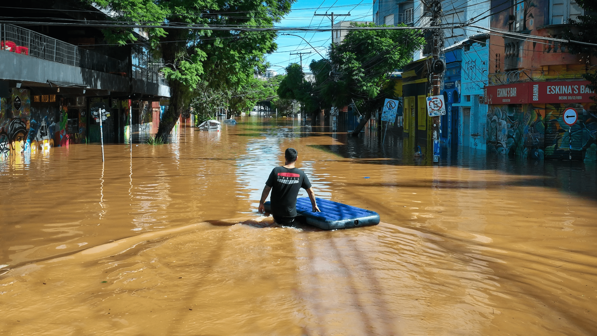 Um morador local caminha por uma rua inundada, enquanto as pessoas são evacuadas de suas casas, em Porto Alegre