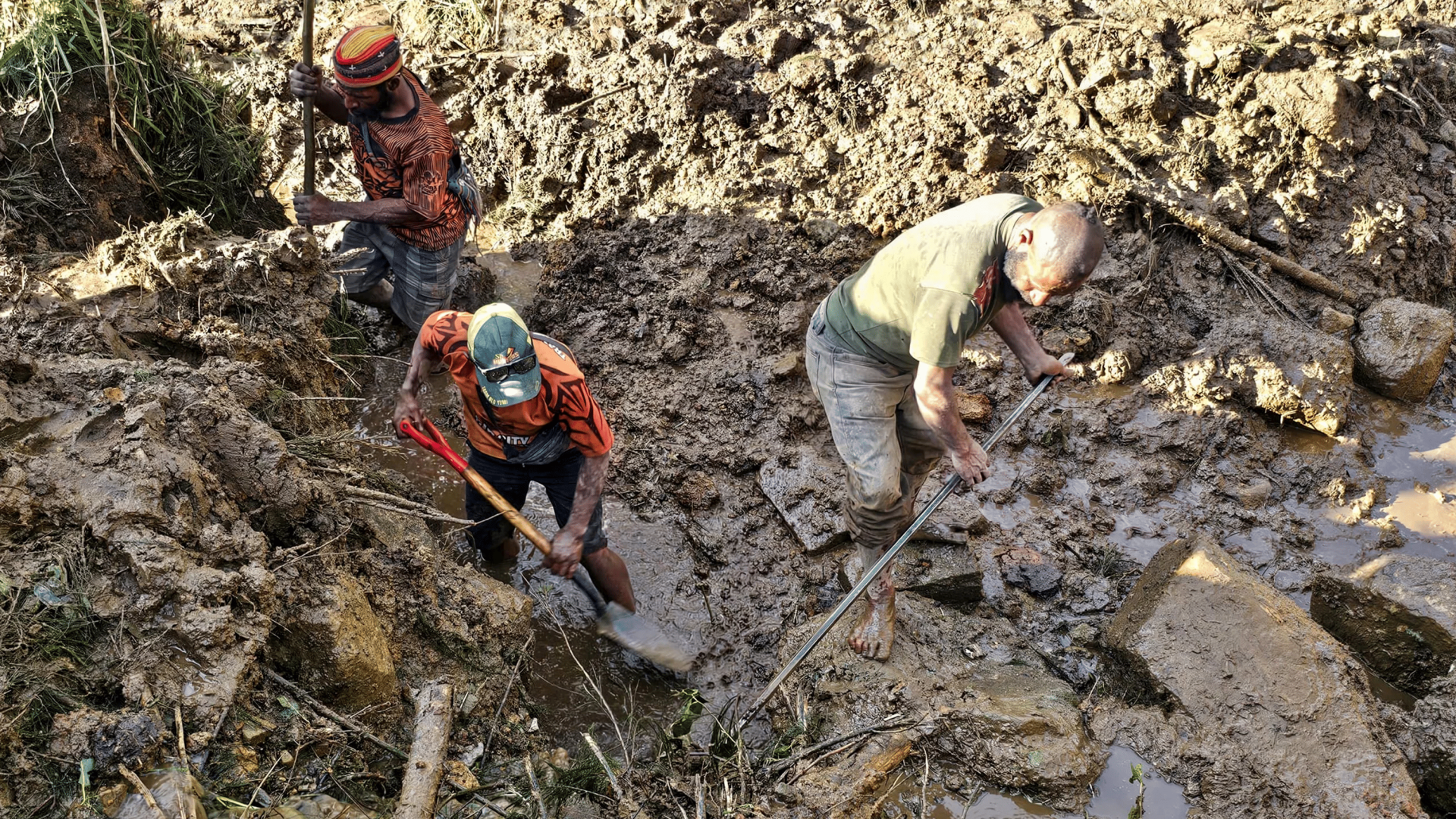 Pessoas escavam escombros no local onde ocorreu um deslizamento de terra, em Papua Nova Guiné.