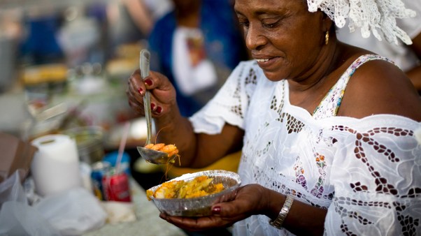 Uma mulher preparando acarajé na feira de Ipanema, Rio de Janeiro.