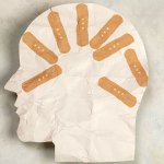 paper art of a head's profile with bandaids.