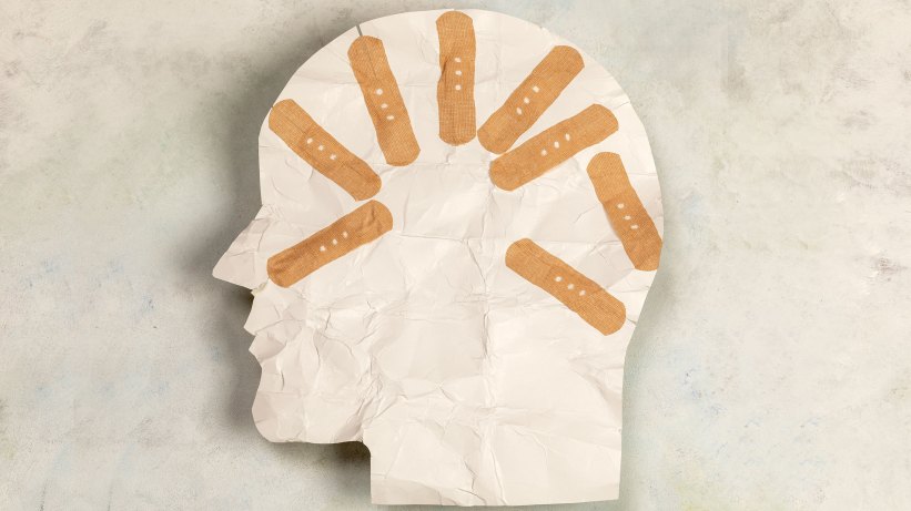 paper art of a head's profile with bandaids.