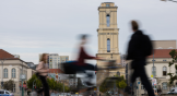 Blurry people walk past a church in Potsdam, Germany