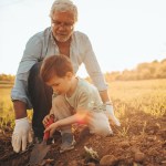 Man teaching a boy how to farm and till the land.