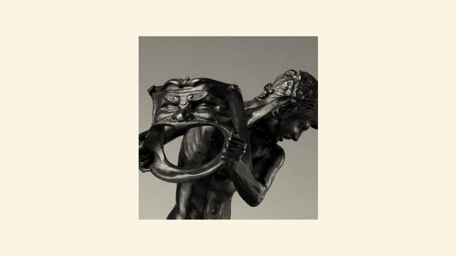 A statue of a man holding a mask