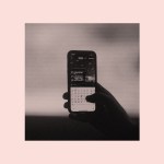 A person holding a phone with emojis