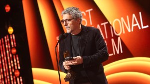 Kleber Mendonça Filho aceitando um prêmio pelo filme O Agente Secreto